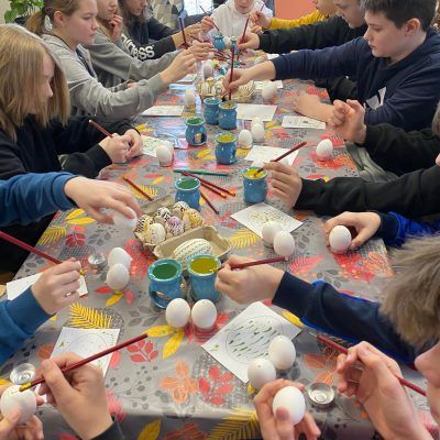 Dzieci przy stole dekorujące pisanki